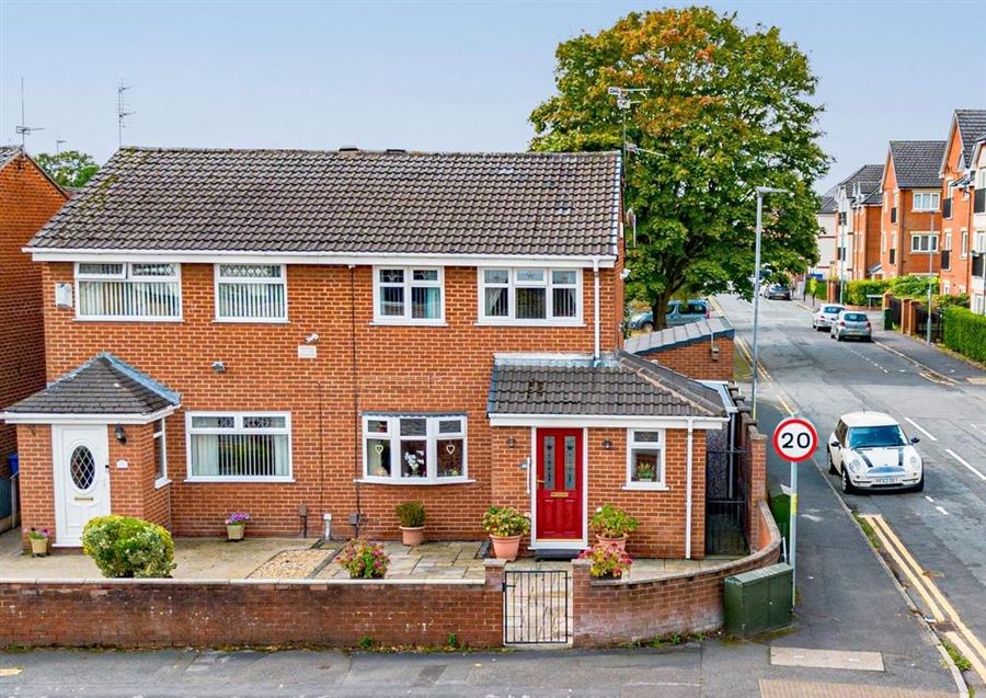 A semi-detached brick house on a residential road.