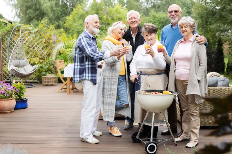 Residents gathered together outdoors at a community garden party.